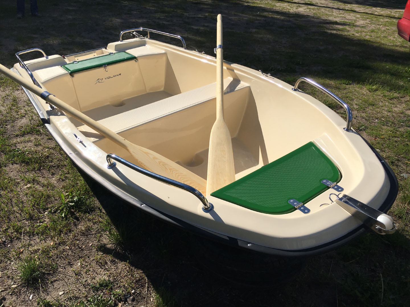 Wydra 300-galeria volmar (15) Na zdjęciu znajduje się mała łódka z jasnym wnętrzem i zielonymi akcentami, z wiosłami leżącymi na pokładzie.